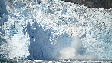 Large splash in the ocean after a piece of glacier calves off into the ocean, Whittier, Alaska, United States of America