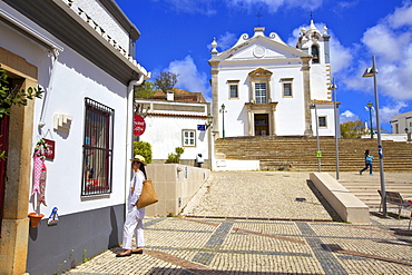 Shopping with The Neo-Classical Igreja Matriz de Estoi Church in the background, Estoi, Eastern Algarve, Algarve, Portugal, Europe