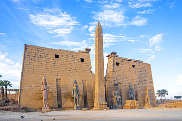 The Pylon of Ramesses ll with the Eastern Obelisk and the Two Colossi of the King seated on his Throne, Luxor Temple, Luxor, Thebes, UNESCO World Heritage Site, Egypt, North Africa, Africa