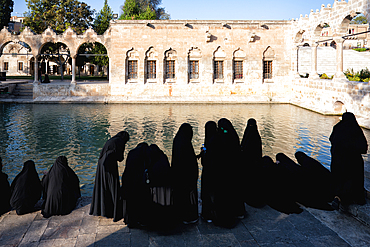 Muslim women wearing abaya in front of Abraham's Pool where the prophet was thrown into fire by King Nimrod, Sanliurfa, Turkey, Asia Minor, Asia