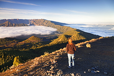 Woman on Birigoyo mountain looking at Cumbre Nueva and Cumbre Vieja at sunset, UNESCO Biosphere Reserve, La Palma, Canary Islands, Spain, Europe