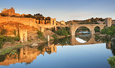 Puente de San Martin Bridge and San Juan des los Reyes Monastery reflected in the Tajo River, Toledo, Castilla-La Mancha, Spain, Europe