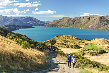 Hiker on Roy's Peak Track enjoying the view over Lake Wanaka, Mount-Aspiring National Park, Otago, South Island, New Zealand, Pacific