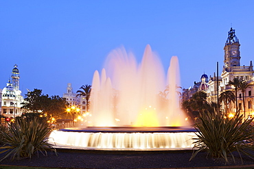 Illuminated fountain on Plaza del Ayuntamineto with town hall at dusk, Valencia, Comunidad Valencia, Spain, Europe 