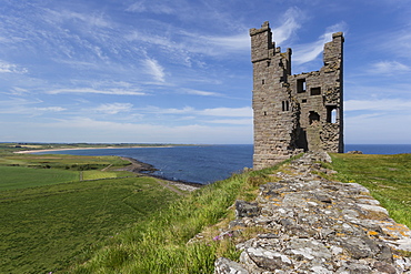 Ruins of Dunstanburgh Castle, overlooking fields and Embleton Bay, Northumberland, England, United Kingdom, Europe