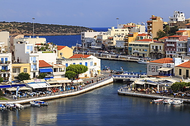 Voulismeni Lake, lined with cafes and restaurants, bridge crosses a narrow channel, Agios Nikolaos, Lasithi, Crete, Greek Islands, Greece, Europe