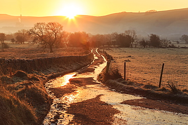 Misty and frosty sunrise over a country lane in winter, Castleton, Peak District National Park, Hope Valley, Derbyshire, England, United Kingdom, Europe