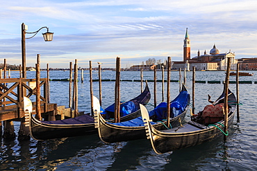 Gondolas, San Marco waterfront at sunset in winter, view to San Giorgio Maggiore, Venice, UNESCO World Heritage Site, Veneto, Italy, Europe