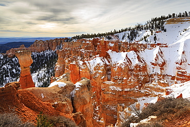 Top-heavy hoodoo, pine trees and cliffs with snow and a cloudy sky, Agua Canyon, Bryce Canyon National Park, Utah, United States of America, North America