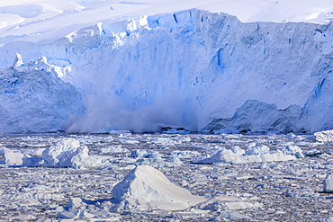 Ice avalanche, glacial calving into iceberg filled Neko Harbour, early morning sun, Graham Land, Antarctic Continent, Antarctica, Polar Regions