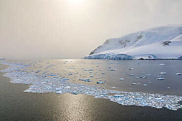 Sun shines through the mist, icy Neumayer Channel between Anvers Island and Wiencke Island, Antarctic Peninsula, Antarctica, Polar Regions