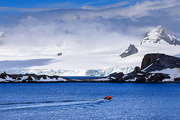 Expedition tourists on a zodiac boat approach Half Moon Island, sunny day, South Shetland Islands, Antarctica, Polar Regions