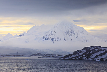 Misty Mount William at sunrise, rising from tidewater glaciers, Anvers Island, Antarctic Peninsula, Antarctica, Polar Regions