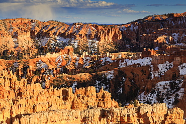 Late afternoon sun lights hoodoos and cliffs with a cloudy sky in winter, near Sunset Point, Bryce Canyon National Park, Utah, United States of America, North America