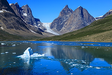 Blue iceberg, pyramidal peaks, glacier, rugged South Skjoldungen Fjord and Island, glorious weather, remote East Greenland, Denmark, Polar Regions