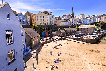 Colourful historic town, St. Mary's church, from Harbour Beach, sunbathers on a sunny day, Tenby, Pembrokeshire, Wales, United Kingdom, Europe