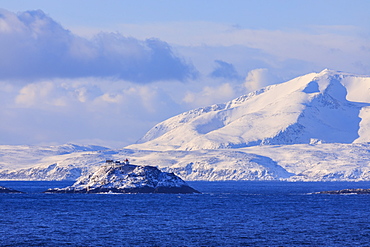 Lighthouse, Norwegian Sea, spectacular snow covered mountains in winter, Troms islands, Arctic Circle, North Norway, Europe