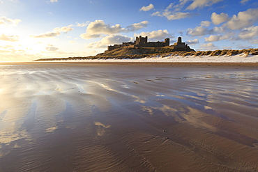 Bamburgh Castle with snow on Bamburgh Beach, Bamburgh, Northumberland, England, United Kingdom, Europe