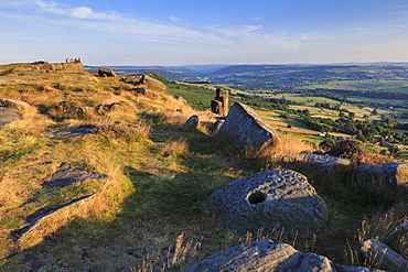 Friends on Curbar Edge with boulders and a millstone in summer, Peak District National Park, Derbyshire, England, United Kingdom, Europe