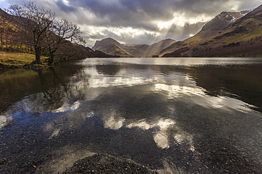 Winter reflections, shafts of sunlight break through clouds, Buttermere, Lake District National Park, Cumbria, England, United Kingdom, Europe