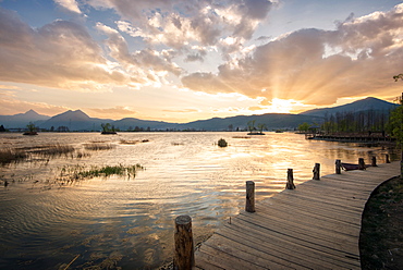 Sunset over mountains, lake and boardwalk in Lijiang, Yunnan, China, Asia 