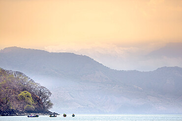 Fishing boats against the looming backdrop of Conchagua Volcano and the Cerro Cacahuatique, El Salvador, Central America