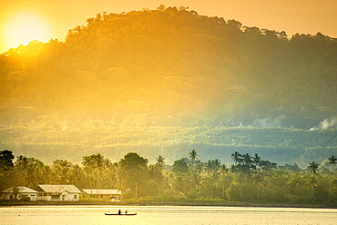 A local fisherman in a traditional canoe in front of the ridges of the Banda islands, Banda, Maluku, Spice Islands, Indonesia, Southeast Asia, Asia