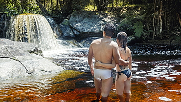 A young heterosexual Latin couple in love enjoying a pristine mountain stream in the Brazilian rainforest, Minas Gerais, Brazil, South America