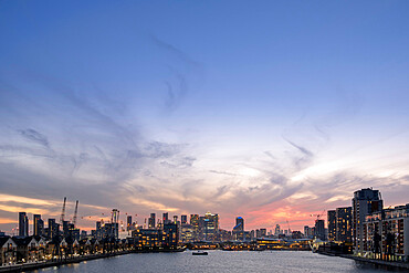 London skyline at dusk with Canary Wharf and the City of London financial districts, the Emirates Cable Car and Victoria Dock, London, England, United Kingdom, Europe