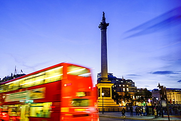 Red bus passing Nelson's Column in Trafalgar Square, London, England, United Kingdom, Europe