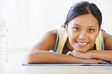 Pacific Islander woman laying on yoga mat