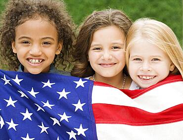 Multi-ethnic girls holding American flag