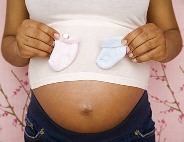 Pregnant African American woman holding booties