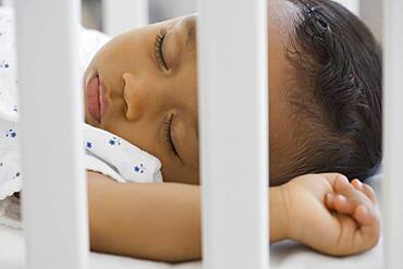 African American baby sleeping in crib