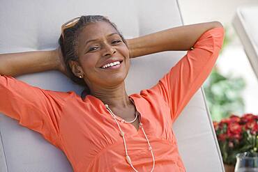 Senior African American woman with hands behind head