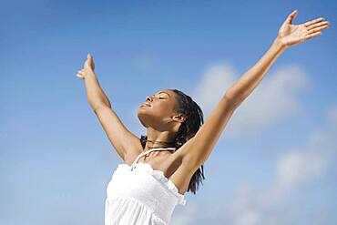 Hispanic woman with arms raised