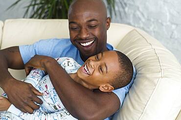 African father tickling son