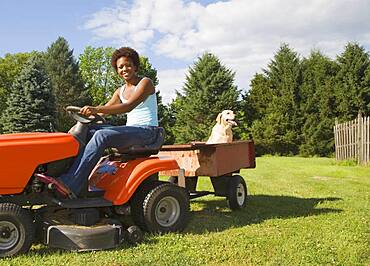 African American woman mowing lawn