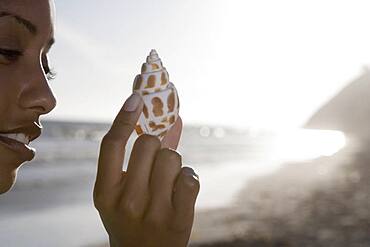 African woman holding seashell