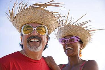 Multi-ethnic couple wearing straw hats