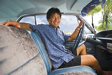 Asian man sitting in car