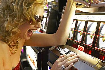 Young woman winning at the slot machine