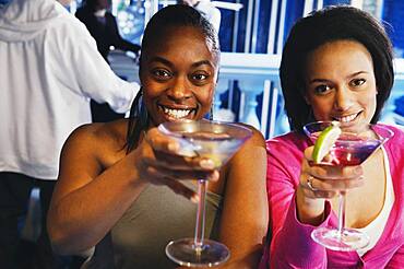 Two African women toasting with cocktails