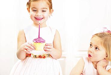 Young girl holding a birthday cupcake