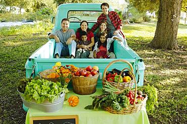 Multi-ethnic family in truck at farm stand