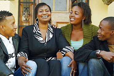 African mother and adult children on porch steps