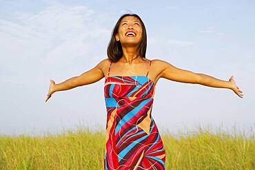 Asian woman with arms outstretched