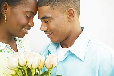 African American couple with foreheads touching and eyes closed