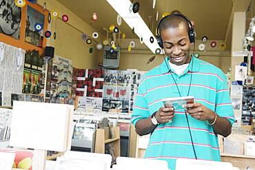 Teenage boy listening to headphones in a music store