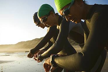 Multi-ethnic swimmers checking watches